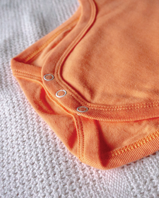 LIMAU sleeveless bodysuit features press-studs at the crotch for easy nappy changes.